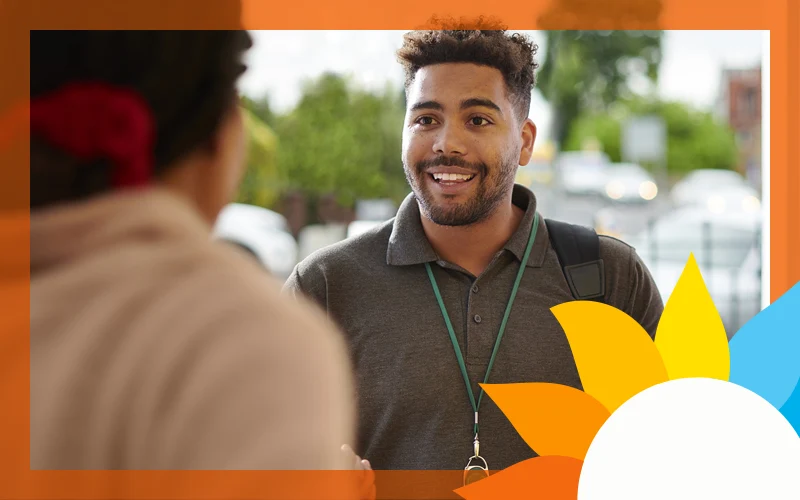 a smiling man speaks to a person
